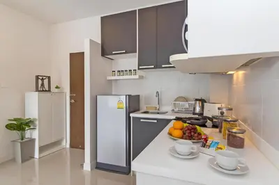 a kitchen with a bowl of fruit on a counter at CHIC CONDO - Best mountain view near Karon beach in Karon Beach
