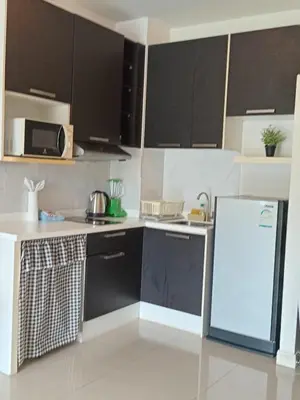 a kitchen with black cabinets and a white refrigerator at CHIC CONDO - Best mountain view near Karon beach in Karon Beach