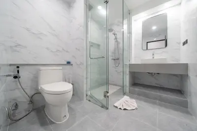 a bathroom with a toilet and a glass shower at Studio Apartment - Nakalay Palm in Kamala Beach