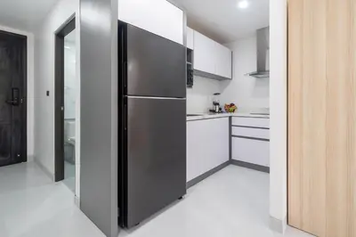 a stainless steel refrigerator in a white kitchen at Studio Apartment - Nakalay Palm in Kamala Beach