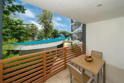 a balcony with a wooden bench and a table at Studio Apartment - Nakalay Palm in Kamala Beach