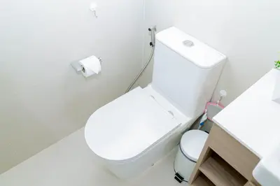 a white bathroom with a toilet and a roll of toilet paper at Laguna Skypark BangTao beach Phuket in Ban Thalat Choeng Thale