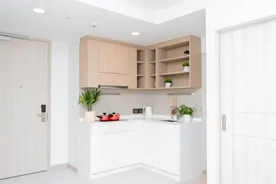 a kitchen with white walls and wooden cabinets at Laguna Skypark BangTao beach Phuket in Ban Thalat Choeng Thale