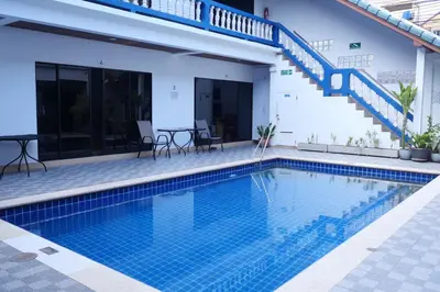 a swimming pool in front of a villa with a staircase at Treff nad phop hotel in Patong Beach