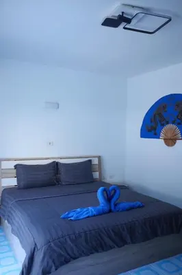 a bed with a blue comforter on top of it at Treff nad phop hotel in Patong Beach