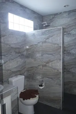 a bathroom with a toilet and a stone wall at Treff nad phop hotel in Patong Beach