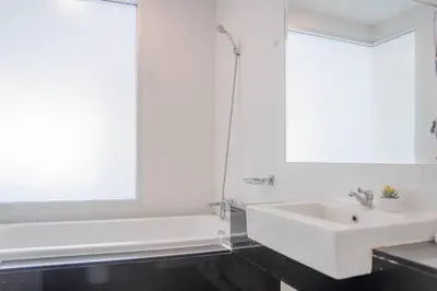 a white bathroom with a sink and a bath tub at Mountain Loft 700m from Beach [Pool & Gym] in Karon Beach