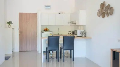 a kitchen with two blue chairs and a counter at Mountain Loft 700m from Beach [Pool & Gym] in Karon Beach