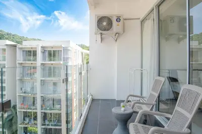a balcony with chairs and a fan on a building at Mountain Loft 700m from Beach [Pool & Gym] in Karon Beach