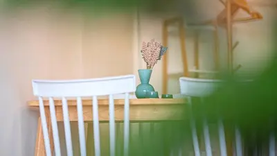 a shelf with two white chairs and a vase with flowers at SeaView 1BR Apartment at Karon Beach in Karon Beach