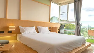 a bedroom with a large bed and a large window at SeaView 1BR Apartment at Karon Beach in Karon Beach