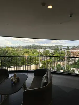 a living room with a couch and a large window at Modern studio in Rawai 600m from the beach in Rawai Beach