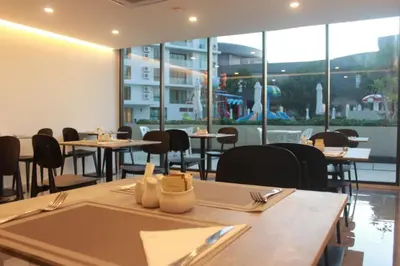 a dining room with tables and chairs and windows at Modern studio in Rawai 600m from the beach in Rawai Beach