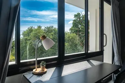 a desk with a lamp in front of a window at Quiet & Comfy studio near Rawai Beach - 
