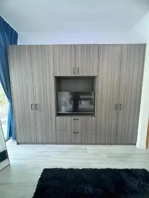 a large wooden cabinet with a television in a living room at Joy Villa - Luxury 4 bedroom villa in Ban Saiyuan (1)