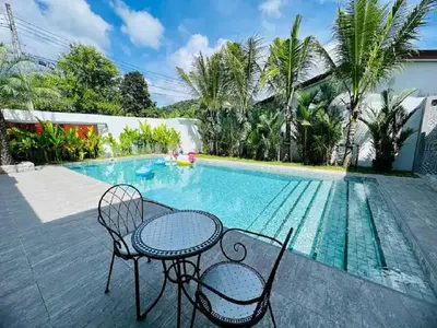 a table and chairs next to a swimming pool at Joy Villa - Luxury 4 bedroom villa in Ban Saiyuan (1)