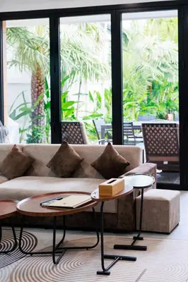 a living room with a couch and two tables at La Ferme Villa - Modern 3 Bedrooms with Private Pool in Rawai Beach