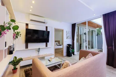 a living room with a flat screen tv on a wall at Lilly Villa - 2 Bedrooms Villa with Private Pool in Rawai Beach