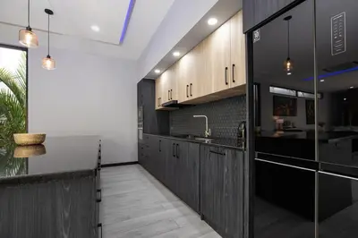a kitchen with dark wood cabinets and a sink at Lynn Villa - 3 Bedrooms with Private Pool in Rawai Beach