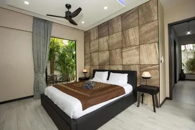 a bedroom with a large bed and a ceiling fan at Lynn Villa - 3 Bedrooms with Private Pool in Rawai Beach