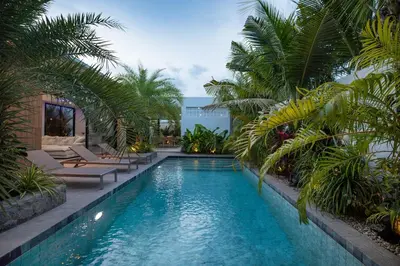 a swimming pool with palm trees in a resort at Lynn Villa - 3 Bedrooms with Private Pool in Rawai Beach