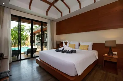 a bedroom with a large white bed and a pool at Orchid Villa - 3 Bedrooms Pool Villa - Rawai beach in Rawai Beach