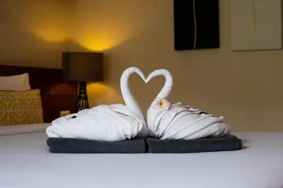 two towels shaped like swans sitting on a bed at Orchid Villa - 3 Bedrooms Pool Villa - Rawai beach in Rawai Beach