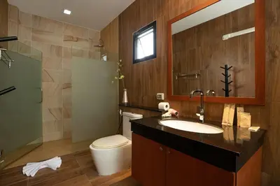 a bathroom with a sink and a toilet and a mirror at Orchid Villa - 3 Bedrooms Pool Villa - Rawai beach in Rawai Beach
