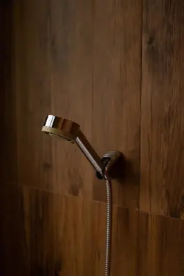 a shower head in a bathroom with a wooden wall at Orchid Villa - 3 Bedrooms Pool Villa - Rawai beach in Rawai Beach