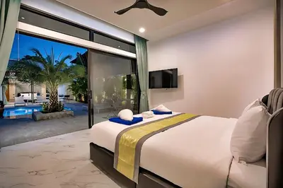a bedroom with a large bed and a large window at Palm Villa - Spacious 4 Bedrooms with Private Pool in Rawai Beach