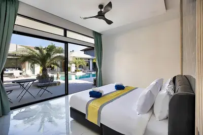 a bedroom with a bed and a balcony with a pool at Palm Villa - Spacious 4 Bedrooms with Private Pool in Rawai Beach
