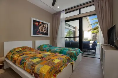 a bedroom with two beds and a tv and a window at Pattana Moon - Luxury Calm 4 Bedrooms Pool Villa in Ban Saiyuan (1)