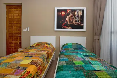 a bedroom with two beds and a picture on the wall at Pattana Moon - Luxury Calm 4 Bedrooms Pool Villa in Ban Saiyuan (1)