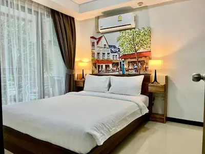 a bedroom with a large bed and a window at Cozy Condotel Maikhao in Mai Khao Beach