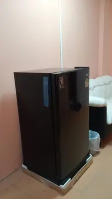 a black refrigerator sitting in the corner of a room at Haweli Restaurant & Guest House in Ao Nang Beach