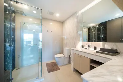 a bathroom with a glass shower and a toilet at Deluxe Surin apartment with washer and fast WIFI in Surin Beach
