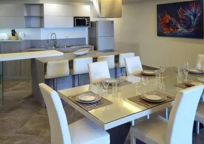 a dining table with white chairs and a kitchen at Karon beach Stylish large 2BR with Sea View in Karon Beach