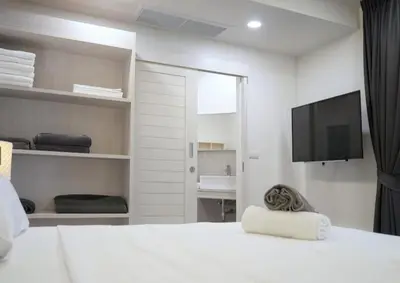 a bedroom with a white bed and a flat screen tv at Karon beach Stylish large 2BR with Sea View in Karon Beach
