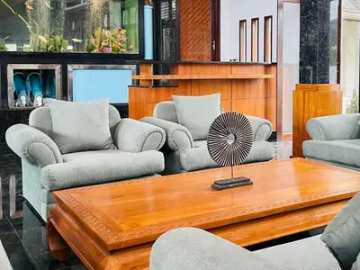 a living room with couches and a table with a fan at Kiri Anda Villa Phuket in Rawai Beach