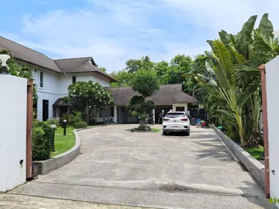 a house with a car parked in the driveway at Kiri Anda Villa Phuket in Rawai Beach