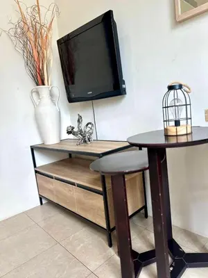 a room with a table and a tv on a wall at Veloche group in Karon Beach