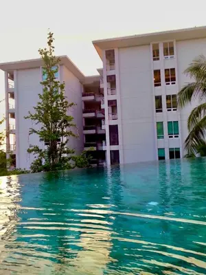 a swimming pool in front of a building at Veloche group in Karon Beach
