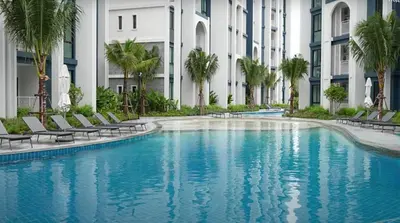 a swimming pool in front of a building with palm trees at Title HALO 1 - Modern 1BR Pool View Walk to Nai Yang Beach in Nai Yang Beach