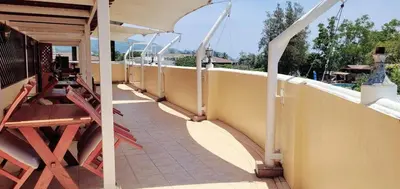 a balcony of a house with a table and benches at Neptuna Kata Beach in Kata Beach