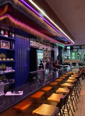 a bar in a restaurant with wooden tables and chairs at Neptuna Kata Beach in Kata Beach