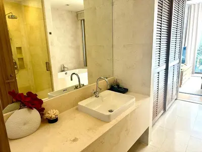a bathroom with a sink and a mirror at Baan Mai Khao beachfront apartments in Mai Khao Beach