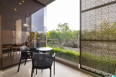 a dining room with a table and chairs and a large window at Baan Mai Khao beachfront apartments in Mai Khao Beach