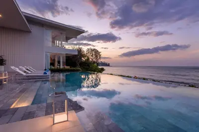 a house with a swimming pool next to the ocean at Villa ANDA in Kamala Beach