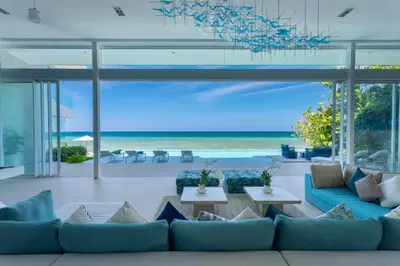 a living room with a blue couch and the ocean at Villa ANDA in Kamala Beach