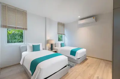 two beds in a room with white and blue at Villa ANDA in Kamala Beach